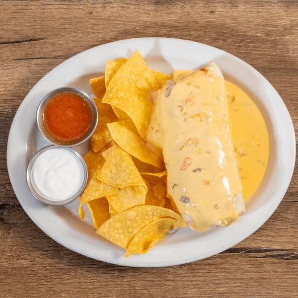 A Don Julio's burrito smothered in queso, surrounded by tortilla chips, salsa, and sour cream.